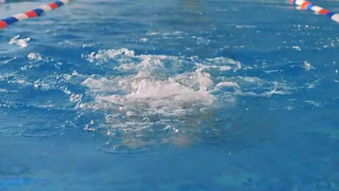 一个女人呼吸空气，淹没在游泳池的水下。