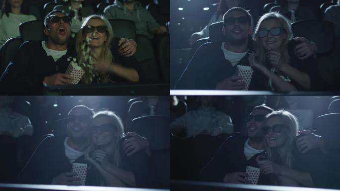 在电影院里有趣的5d电影放映中，当爆米花被从盒子里摇出来时，夫妻俩互相拥抱。