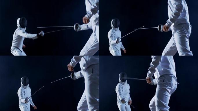 两名专业装备齐全的击剑手熟练地用箔纸战斗。他们进攻、防守、跳跃、推力和弓步。拍摄孤立在黑色背景上。