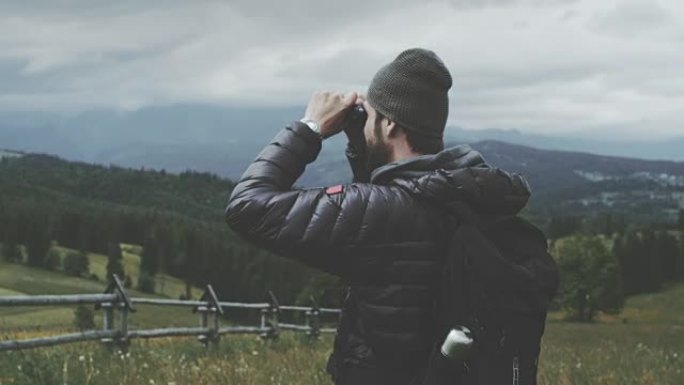 用双筒望远镜看的人。多山的地形