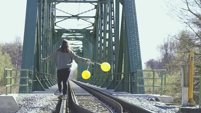 WS年轻女子带着气球在铁轨上行走