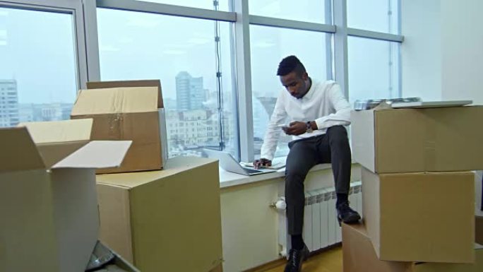 年轻的非洲经理搬进办公室后在窗台上工作