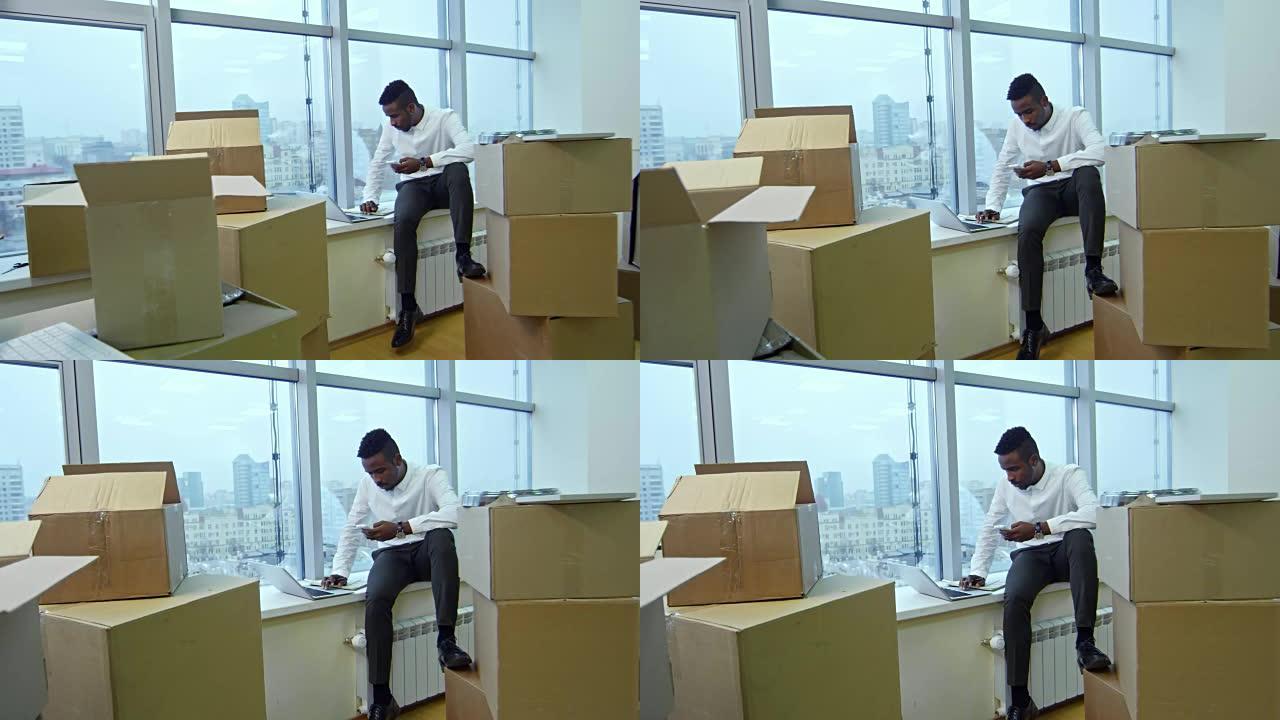 年轻的非洲经理搬进办公室后在窗台上工作