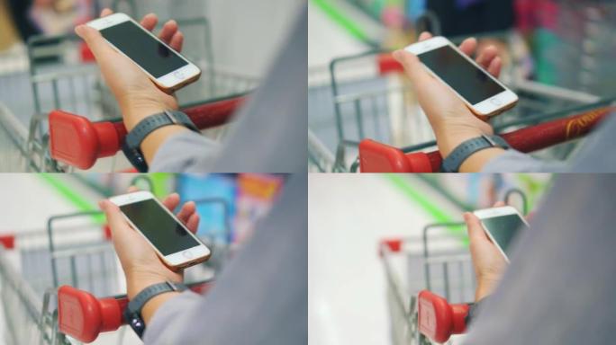 在超市使用智能手机的女人