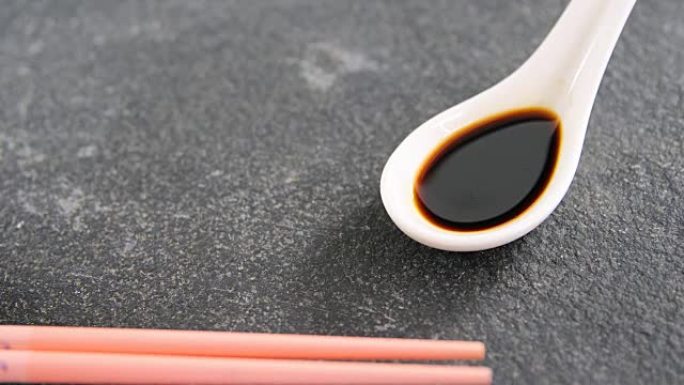 黑色石板上的筷子和酱油
