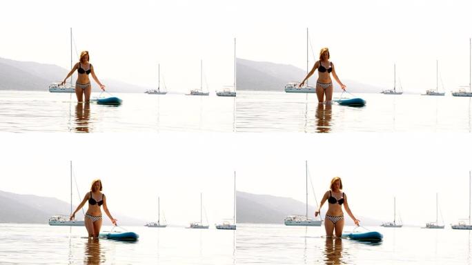 女人带着一块冲浪板走回海滩