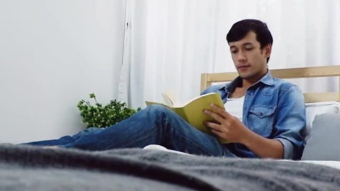 一个男人躺在床上在卧室里看书