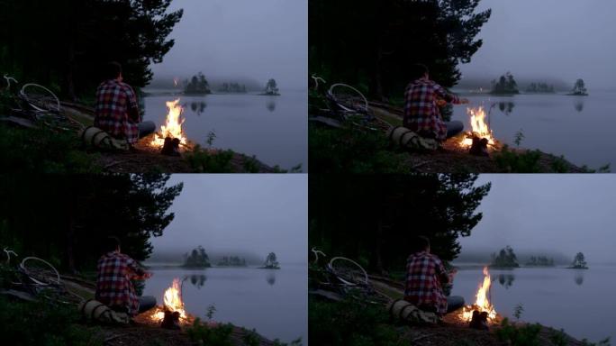 湖边的篝火。人在火旁取暖。无人机的观点