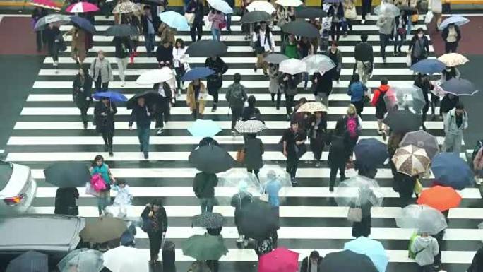 日本人人群的4k镜头在东京新宿商圈新宿JR站的建筑物之间过马路