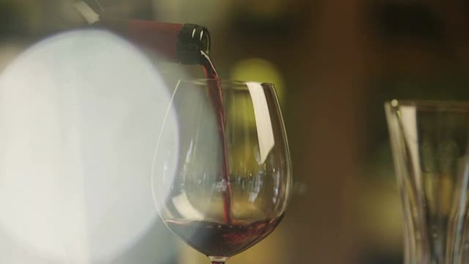 侍酒师在餐厅用葡萄酒填充杯子。特写。