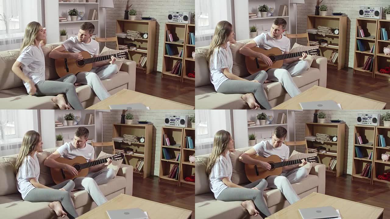 年轻人在家为女友弹吉他