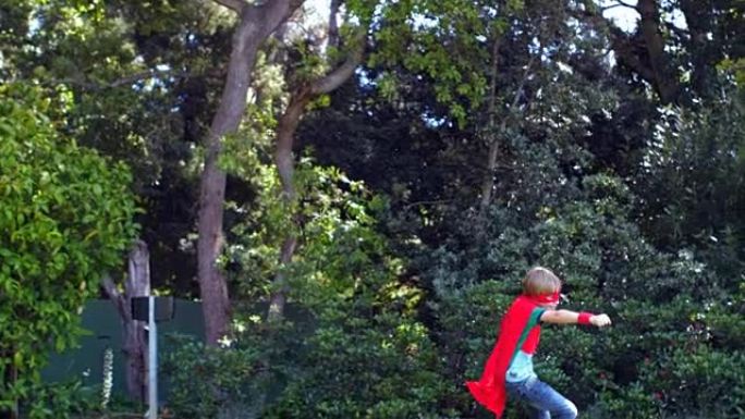 可爱的男孩在花园里扮演超级英雄