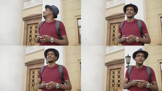 非裔美国人微笑的旅游男子使用智能手机在线地图找到站在街道上的正确方向