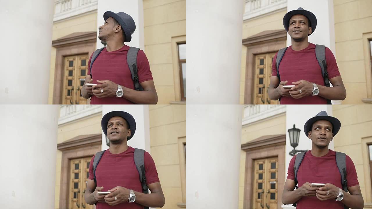 非裔美国人微笑的旅游男子使用智能手机在线地图找到站在街道上的正确方向