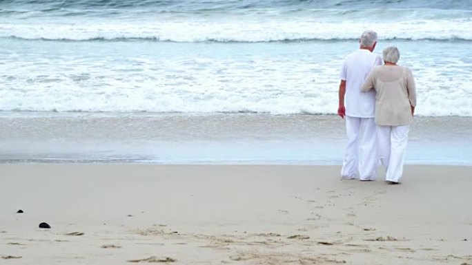 在沙滩上散步的高级夫妇