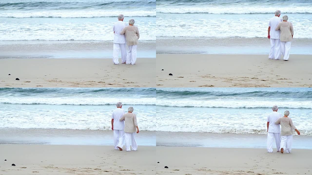 在沙滩上散步的高级夫妇