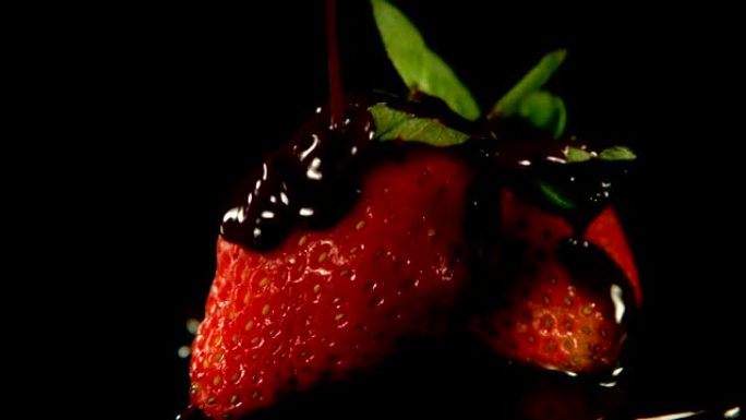 融化的巧克力倒在草莓上