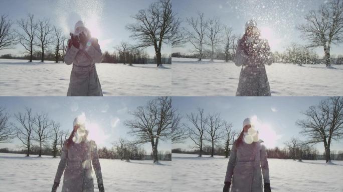 慢动作: 微笑的年轻女子将雪吹入相机