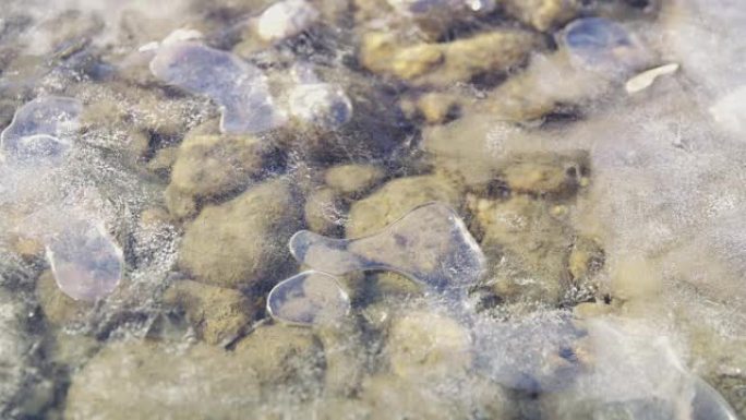 冰冷的河面下的铜水泡和石头