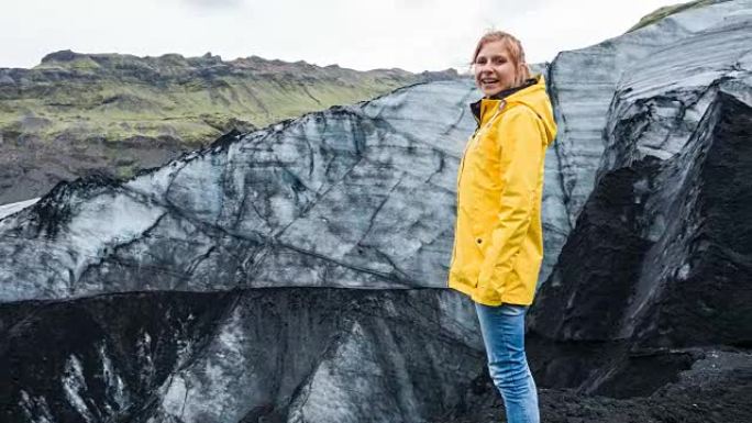 欣赏被火山灰覆盖的冰岛冰川的女性游客