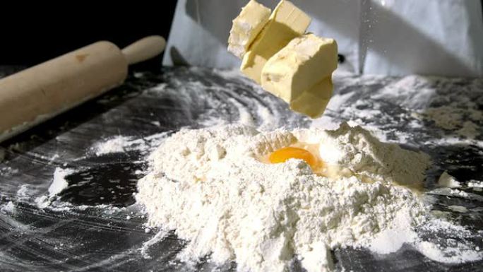 厨师在生鸡蛋和面粉中加入黄油