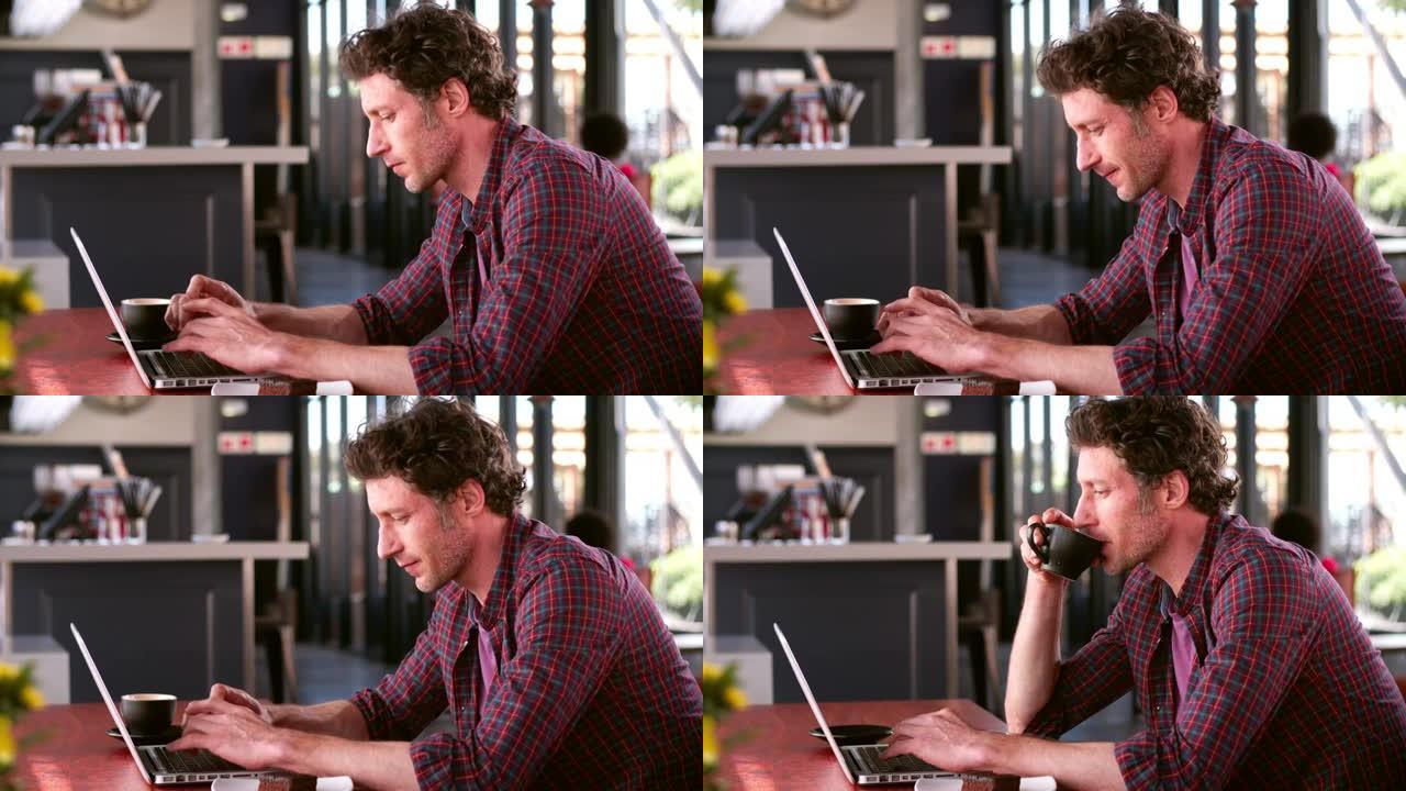 咖啡馆里成熟的男人在笔记本电脑上工作