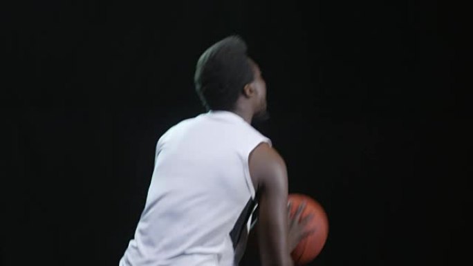 篮球运动员在黑色背景上投掷球