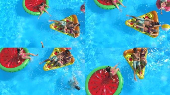 空中: 顽皮的人在泳池水中充气的彩色浮标上玩乐