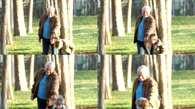 男孩拉着他的祖父，在公园散步