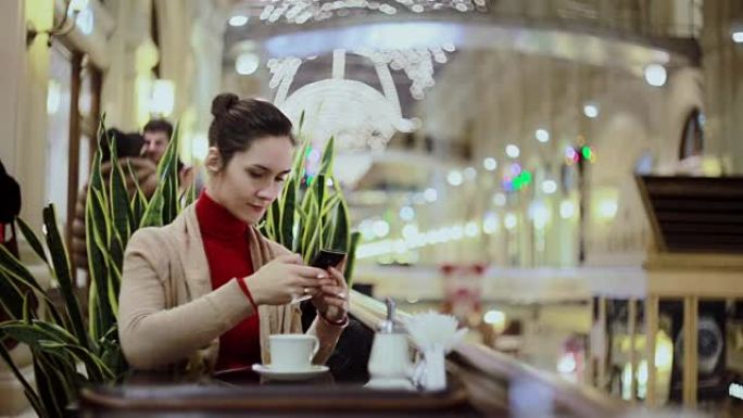 女人使用智能手机，在咖啡馆喝咖啡