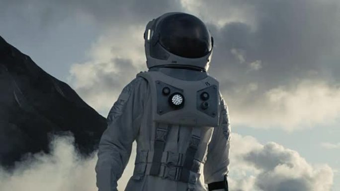 中镜头的宇航员穿着宇航服行走和探索灰色冰冻岩石外星球。科技进步带来了太空探险、探索和殖民。