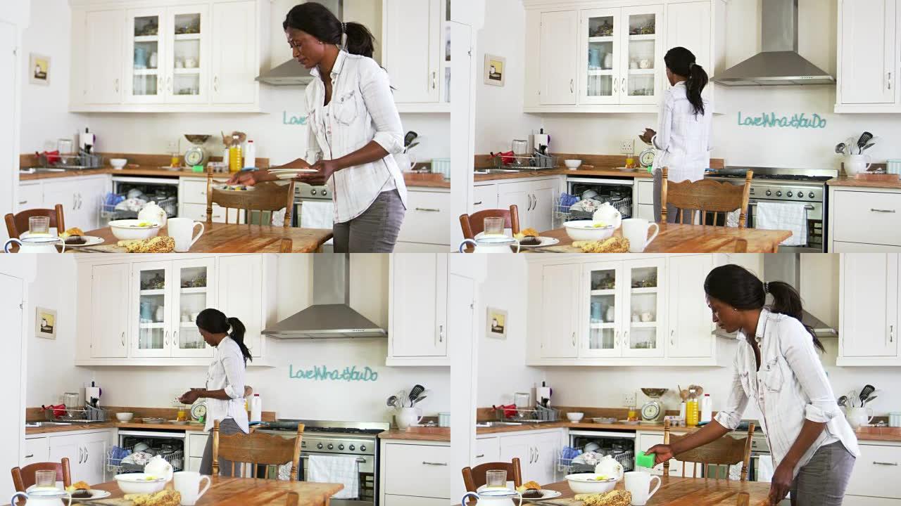 女人清理早餐桌和装载洗碗机