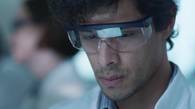 拉丁裔科学家使用平板电脑，眼镜中有屏幕反射。