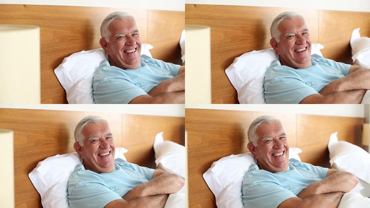老人躺在床上对着镜头微笑
