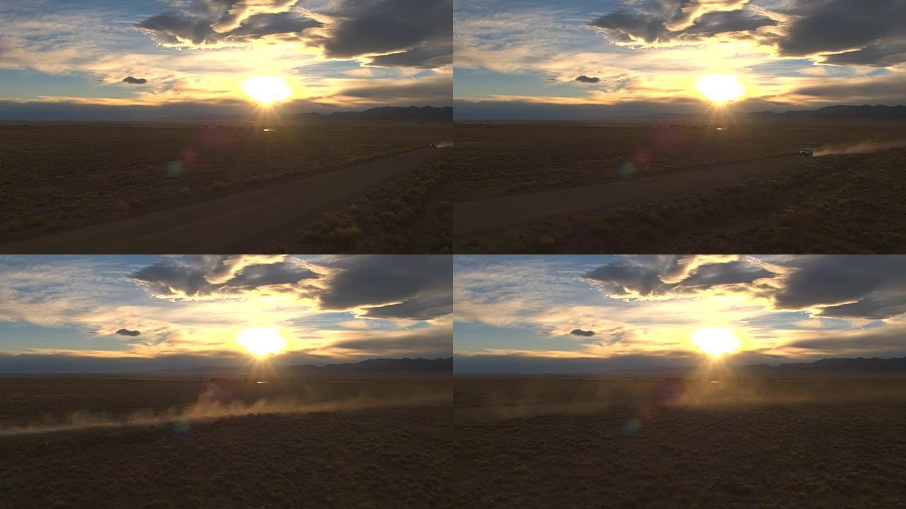空中飞车在日落时分穿越广阔的沙漠山谷的土路上扬起灰尘
