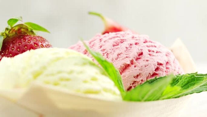 特写，香草和草莓冰淇淋饰以新鲜草莓和新鲜的menta