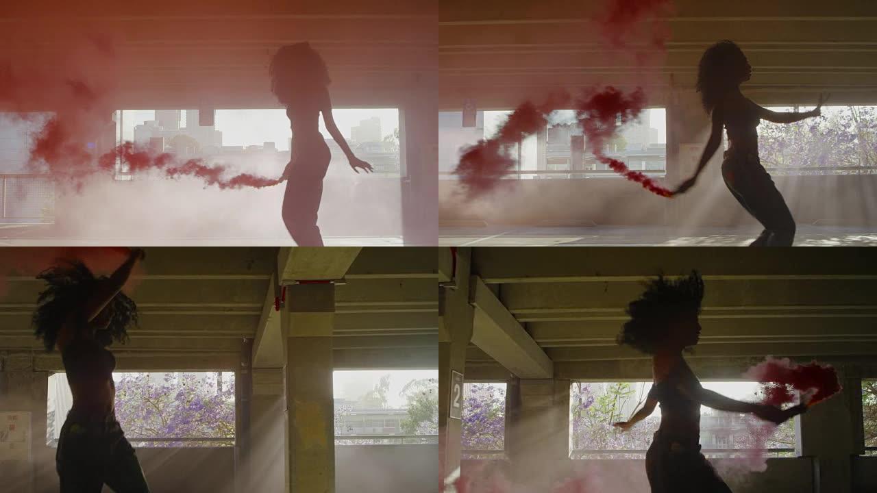 剪影年轻女子在停车场用彩色红色烟雾弹跳舞
