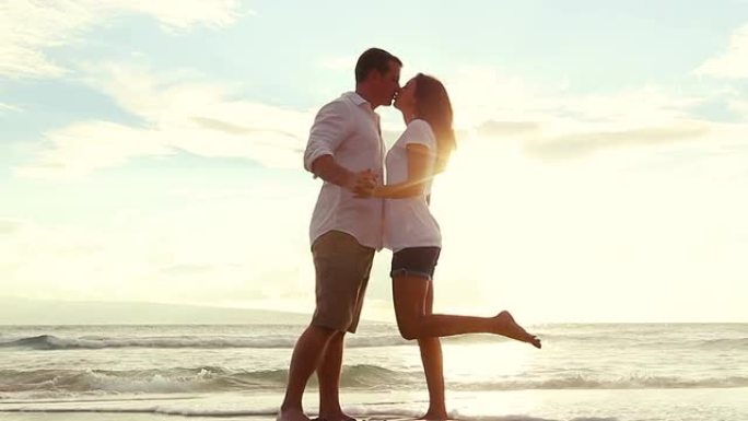 热情的情侣在海滩日落时接吻