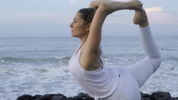 在海岸线上做瑜伽的女人