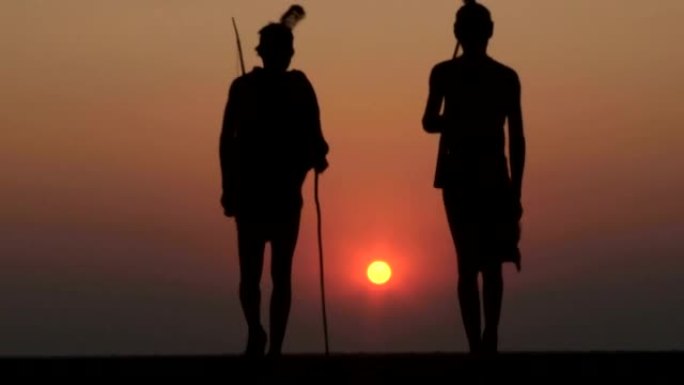布须曼人在Makgadikgadi pan的夕阳下行走