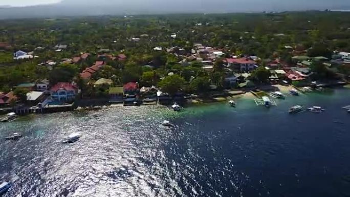 鸟瞰图飞越令人惊叹的沙滩，游客在菲律宾宿务奥斯洛布附近的苏米隆岛海滩美丽清澈的海水中游泳。