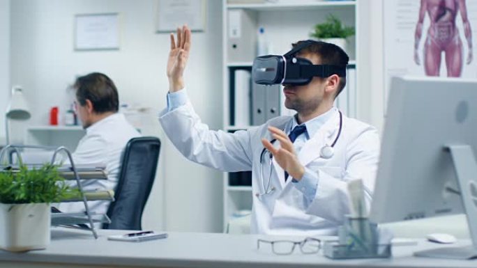男医生戴着虚拟现实耳机进行实验医疗程序。他的助手密切监视办公桌上的活动。办公室轻巧，超现代。