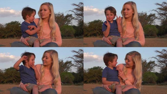 四岁男孩坐在母亲的大腿上互动，南非