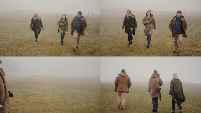 雾天一起徒步旅行的朋友。两个女人和男人一起探索冰岛，享受大自然