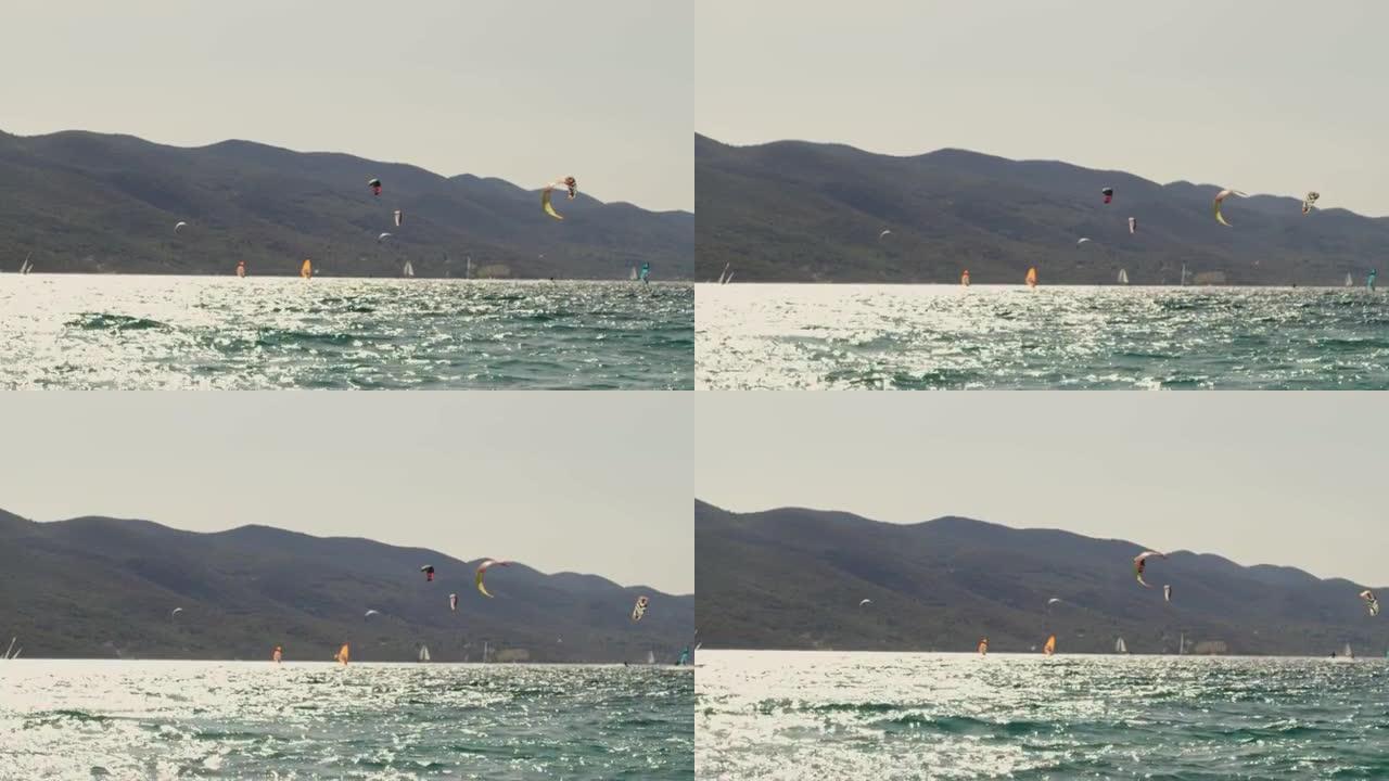 SLO MO风筝冲浪者和风帆冲浪者在海湾冲浪