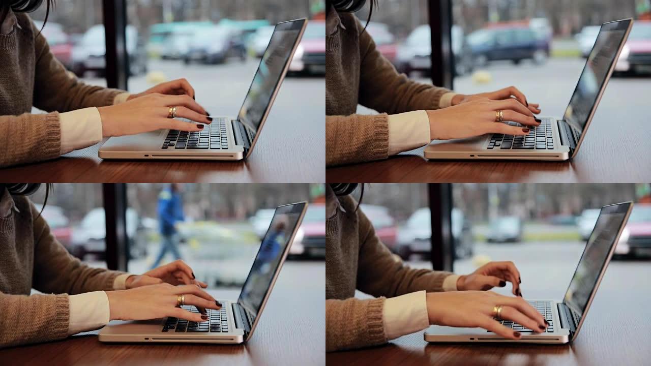 咖啡馆里的女性手在笔记本电脑上工作。静态