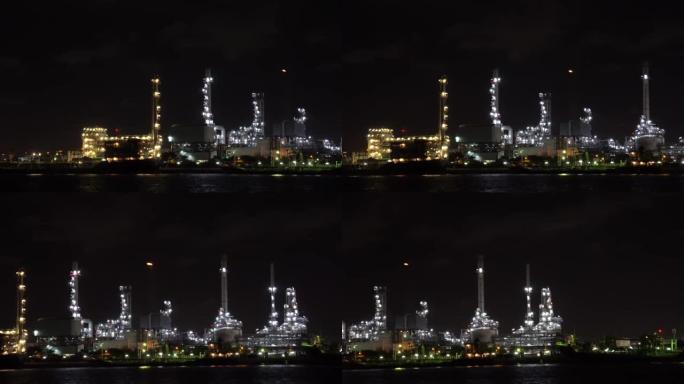 泰国曼谷夜间特写炼油厂河边的4k镜头。录像，工业工厂概念