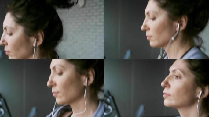 女人在健身房锻炼时听音乐