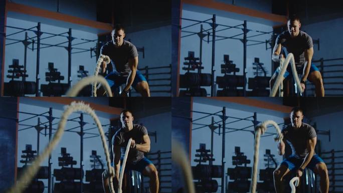 运动男子在健身房用绳索锻炼