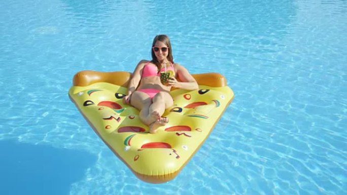 特写: 微笑的女孩在充气披萨漂浮物上享受暑假